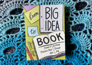 Print version of From Big Idea to Book by Jessie Kwak sitting on a monochrome blue crocheted background