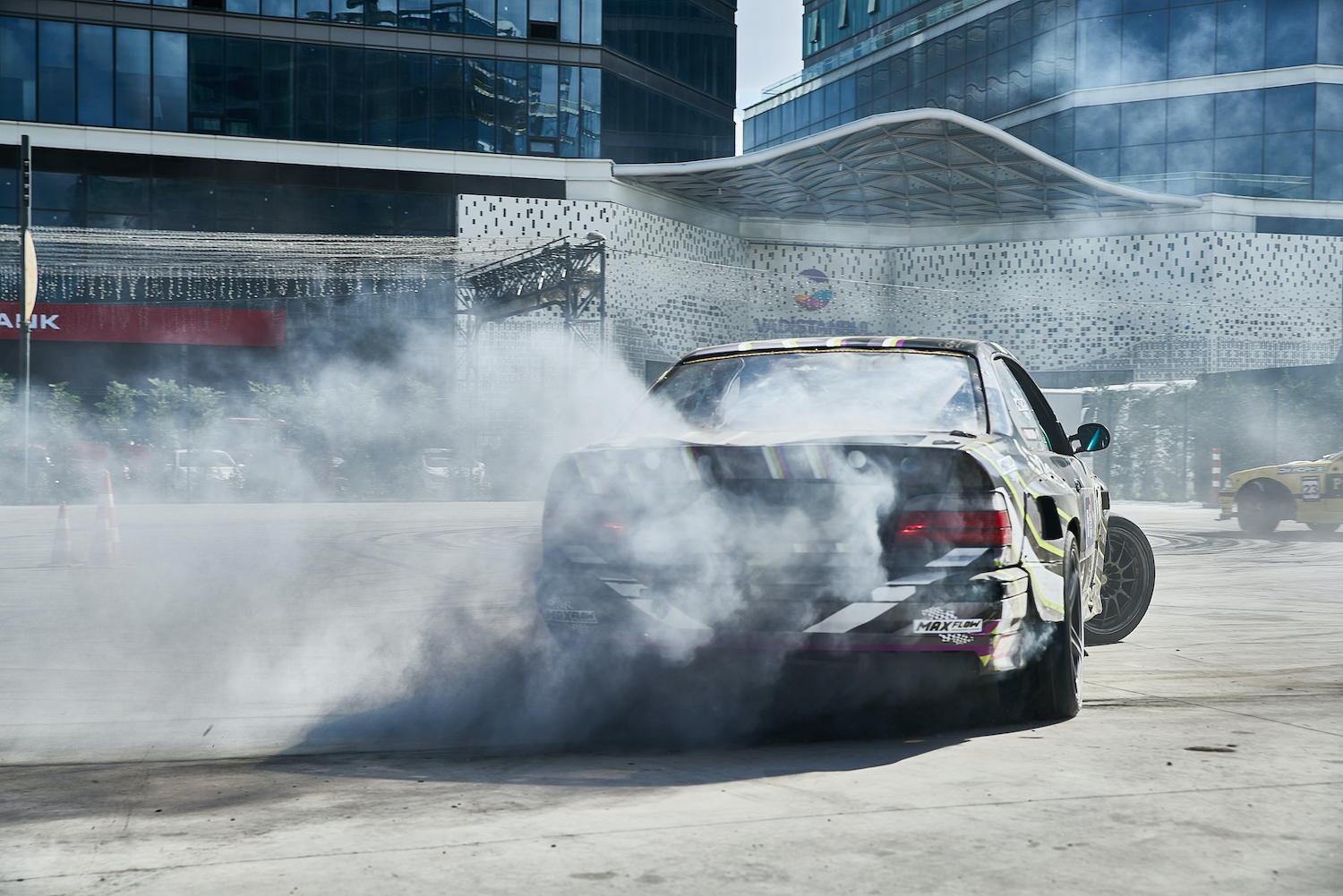 Gray drift car slamming on its brakes and leaving a trail of smoke behind it